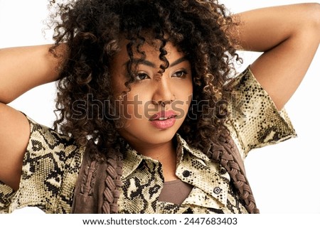 tasteful african american woman with animalistic print on outfit looking away on white backdrop