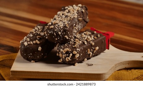 A tasteful popsicle, with chocolate, nuts and peanuts.