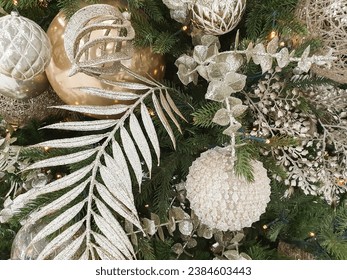 Tasteful silver, white and gold Christmas tree decorations having on green fir tree