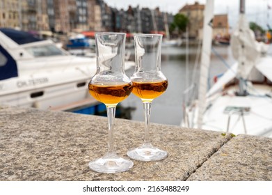 Tasting Of Apple Calvados Drink From Glasses In Old Honfleur Harbour With Boats And Old Houses On Background, Normandy, France