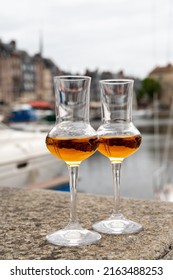 Tasting Of Apple Calvados Drink From Glasses In Old Honfleur Harbour With Boats And Old Houses On Background, Normandy, France