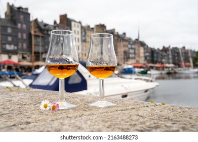 Tasting Of Apple Calvados Drink From Glasses In Old Honfleur Harbour With Boats And Old Houses On Background, Normandy, France