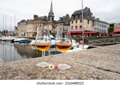 Tasting Of Apple Calvados Drink From Glasses In Old Honfleur Harbour With Boats And Old Houses On Background, Normandy, France