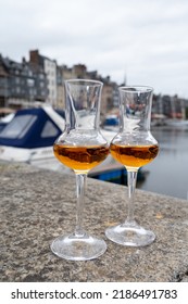 Tasting Of Apple Calvados Drink From Glasses In Old Honfleur Harbour With Boats And Old Houses On Background, Normandy, France