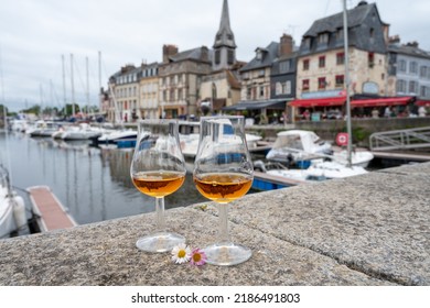 Tasting Of Apple Calvados Drink From Glasses In Old Honfleur Harbour With Boats And Old Houses On Background, Normandy, France