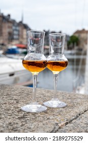 Tasting Of Apple Calvados Drink From Glasses In Old Honfleur Harbour With Boats And Old Houses On Background, Normandy, France