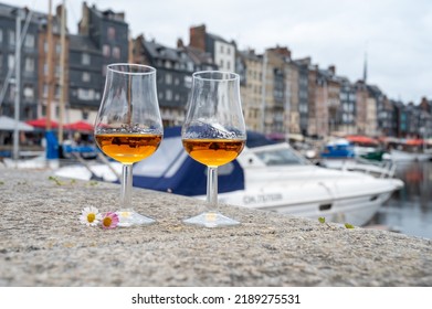 Tasting Of Apple Calvados Drink From Glasses In Old Honfleur Harbour With Boats And Old Houses On Background, Normandy, France