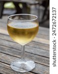 Tasting of Bordeaux white wine in Sauternes, left bank of Gironde Estuary, France. Glasses of white sweet French wine served for lunch in outdoor restaurant