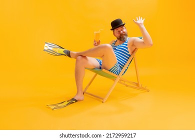 Tasting Cold Beer. Studio Shoot Of Cool Funny Beachgoer, Man In Vintage Striped Swimsuit And Bowler Hat Sitting In Sunbed Isolated On Yellow Background. Leisure Activity, Vacation, Summer, Sales