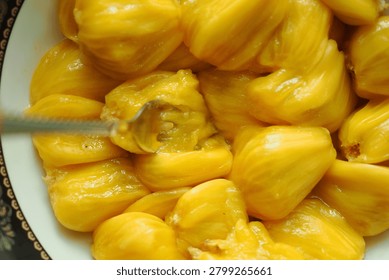 Tasting fresh jackfruit in a kitchen setting