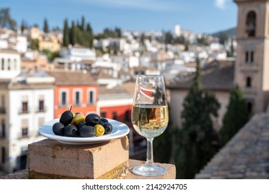 Tasting of Spanish sweet and dry fortified Vino de Jerez sherry wine and olives with view on roofs and houses of old andalusian town, South of Spain