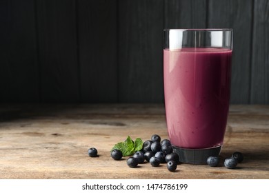 Tasty Acai Drink In Glass And Berries On Wooden Table. Space For Text