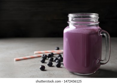 Tasty Acai Drink In Mason Jar  And Berries On Grey Table, Space For Text