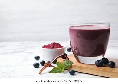 Tasty Acai Drink, Powder And Berries On Marble Table. Space For Text