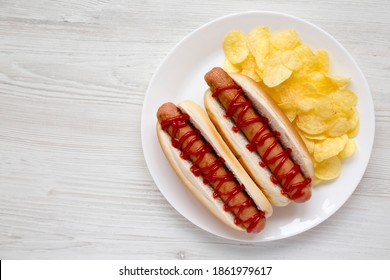 Tasty American Hot Dog With Potato Chips On A White Plate On A White Wooden Background, Top View. Flat Lay, Overhead, From Above. Copy Space.