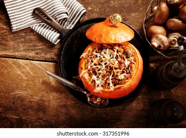 Tasty Autumn Stuffed Pumpkin With Fresh Mushrooms Ready To Serve For A Seasonal Dinner, Overhead View On Rustic Wooden Table With Copyspace