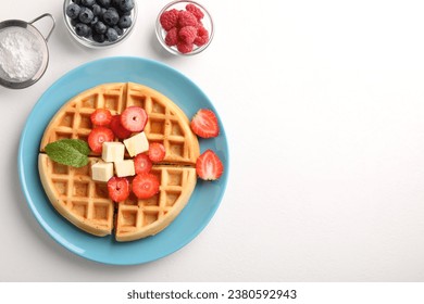 Tasty Belgian waffle with fresh berries, cheese and honey on white table, flat lay. Space for text - Powered by Shutterstock