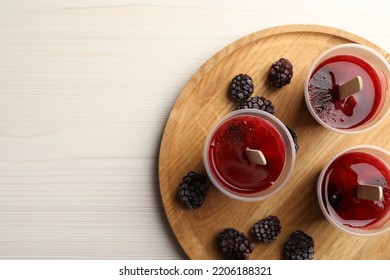 Tasty Berry Ice Pops In Plastic Cups And Space For Text On White Wooden Table, Top View. Fruit Popsicle