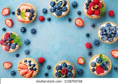 Tasty berry tartlets or cake with cream cheese and different berries around. Pastry dessert top view. - Powered by Shutterstock