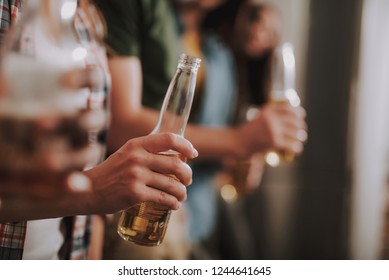 Tasty beverage. Close up of female hand holding bottle of beer. Copy space in right side