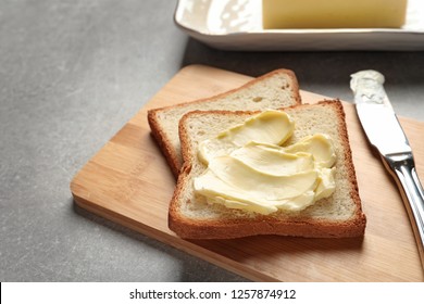 Tasty Bread With Butter And Knife On Wooden Board