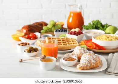 Tasty breakfast. Croissants, jam, honey and other food on light table