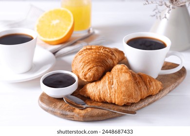 Tasty breakfast. Cup of coffee, jam and croissants on white wooden table - Powered by Shutterstock