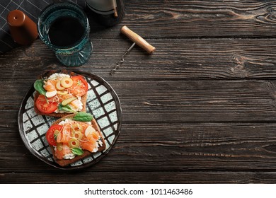Tasty bruschettas with olives and salmon on plate
