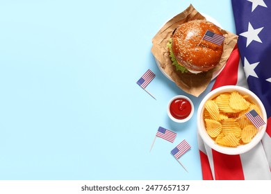 Tasty burger with flags of USA and potato chips on blue background. American Independence Day celebration - Powered by Shutterstock