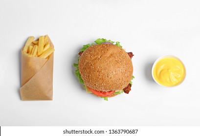 Tasty burger, french fries and sauce on white background, top view - Powered by Shutterstock