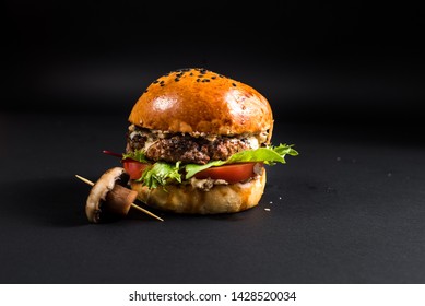 Tasty Burger With Grilled Meat And Mushroom On The Black Background