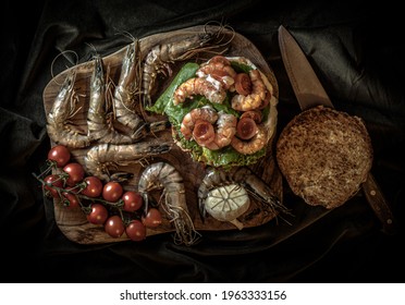 A Tasty Burger With Schrimps Shot In A Old Flemish Painting Style. Top View.