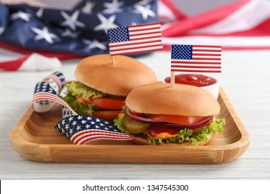 Tasty burgers with USA flags and sauce on table. Traditional American food - Powered by Shutterstock