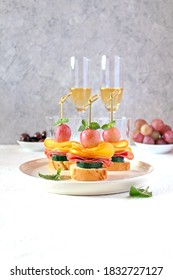 Tasty Canapes With Cucumber, Salami, Cheese And Grapes Served With White Wine. Top View With Copy Space.