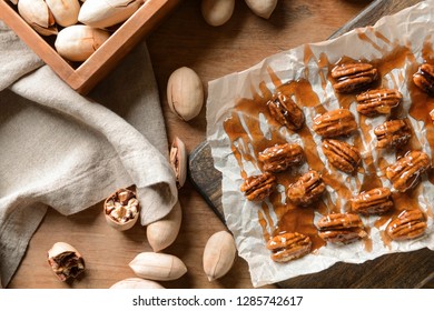 Tasty Candied Pecan Nuts On Wooden Table