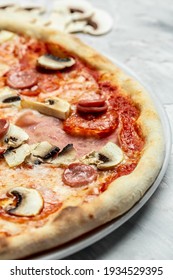 Tasty Capriciosa pizza. Classic pizza with ham and mushrooms. Italian pizza is cooked in a wood-fired oven. vertical image, Food recipe background. Close up.