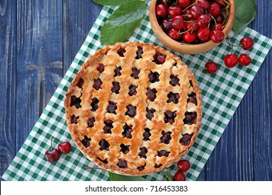 Tasty cherry pie and bowl with fresh berries on wooden table