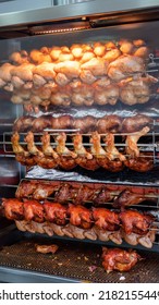 Tasty Chicken, Chicken Legs And Turkey Drumsticks On A Rotisserie In The Restaurant