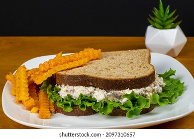 A Tasty Chicken Salad  Sandwich Served With Butternut Squash Fries