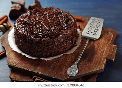 Tasty chocolate cake on color wooden background
