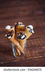 Tasty Chocolate Ice Cream In Waffle Cone On Brown Wooden Background