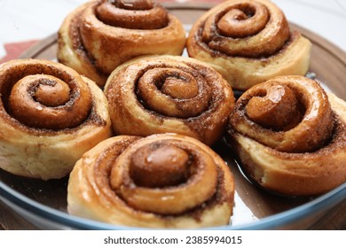 Tasty cinnamon rolls on in baking dish table, closeup - Shutterstock ID 2385994015