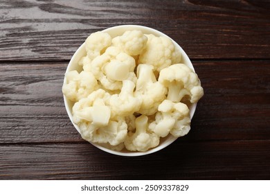 Tasty cooked cauliflower on wooden table, top view