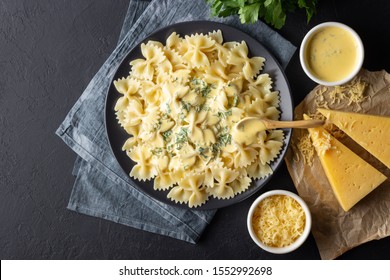 Tasty cooked italian farfalle pasta (bow-tie or butterfly) with cheese sauce. Top view. Black background. - Powered by Shutterstock