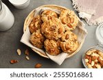 Tasty cookies with nuts and milk on grey table, flat lay