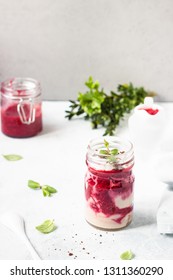 Tasty Cottage Cheese Parfait With Raspberry Sauce And Mint In A Glass Jar. Diet Dessert. Light Grey Stone Concrete Background. Copy Space.