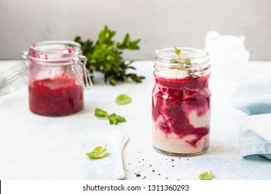 Tasty Cottage Cheese Parfait With Raspberry Sauce And Mint In A Glass Jar. Diet Dessert. Light Grey Stone Concrete Background. Copy Space.