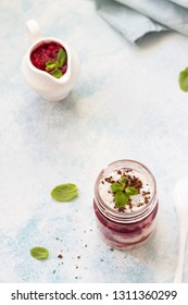 Tasty Cottage Cheese Parfait With Raspberry Sauce And Mint In A Glass Jar. Diet Dessert. Light Grey Stone Concrete Background. Copy Space.