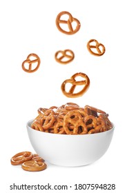 Tasty Crispy Pretzel Crackers Falling Into Bowl On White Background