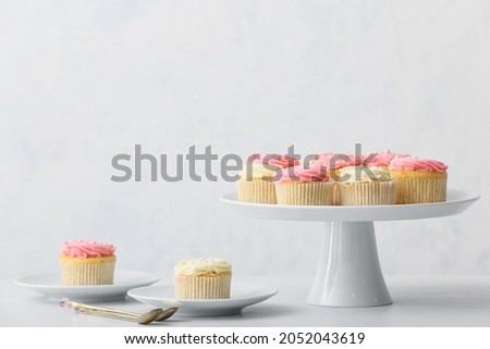 Tasty cupcakes on light background